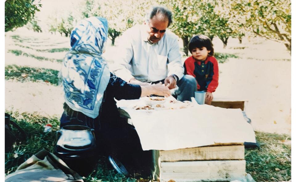Aysan as a child with her grandparents in an apple orchard