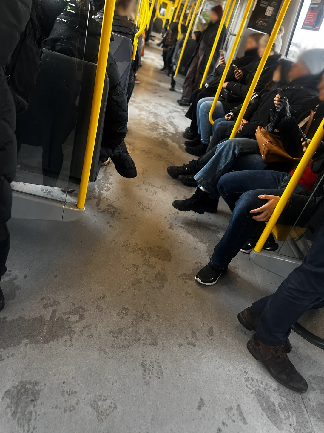 Passengers seated inside a tram, with faces blurred